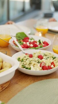 Food, hands and family with sharing lunch in home for nutrition, wellness or health meal together. Hosting, salad and group of people eating in dining room for serving vegetables for diet in house.