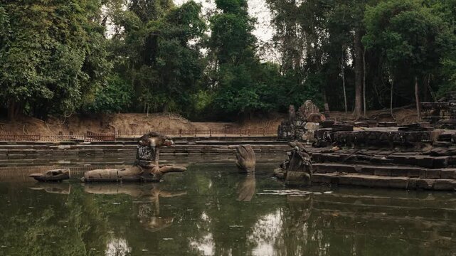 Ancient Khmer stone ruins reflected in calm temple pool in Cambodia