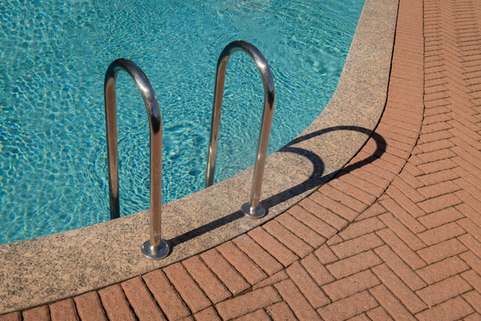 metal swimming pool ladder and shadow in summer