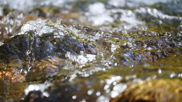 Close-up video of the surface of a turbulent mountain river with clear, clear water at 4x slower speed and a front view of the current just above at an angle. Soothing shots of nature, 30 fps full hd