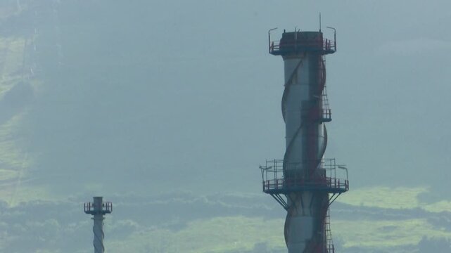 Close up of a tall industrial chimney with spiral detailing and observation