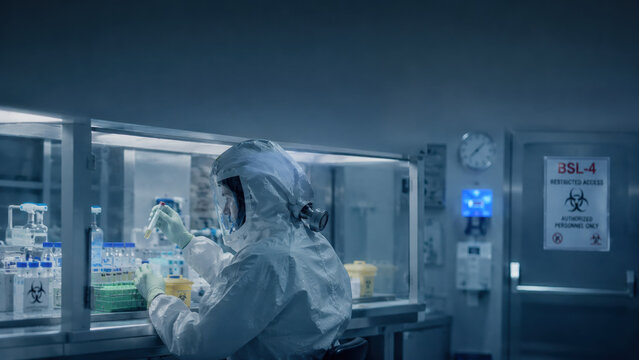 Ebola virus, biosafety,level, laboratory. Scientist observing test samples through protective glass barrier