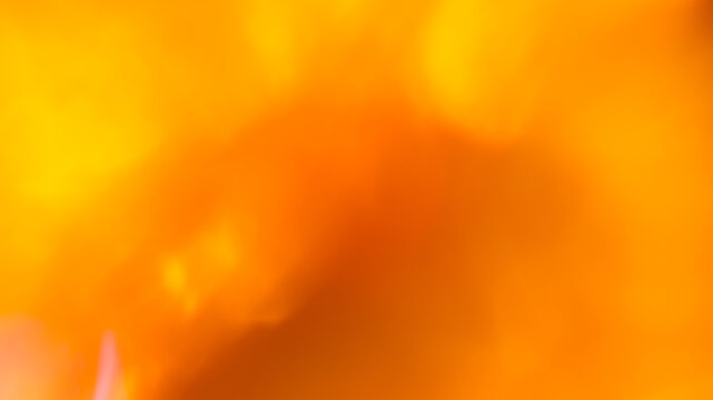 Vibrant orange and yellow abstract background with warm fiery bokeh and glowing light for energetic backdrop