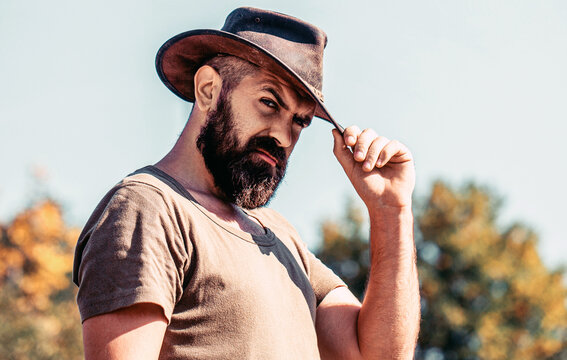 Man wearing cowboy hat. Cowboys in hat. Man unshaven cowboys. Handsome bearded macho