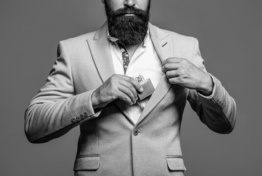 Fragrance and perfumery, cosmetics. Bearded man holding up bottle of perfume. Fashion cologne bottle. Black and white