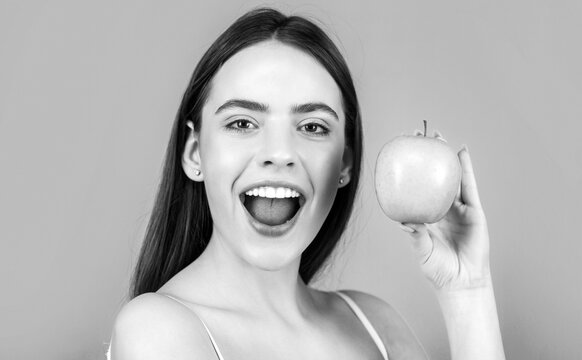 Beautiful happy smiling woman with green apples. Healthy diet food. Stomatology concept. Woman with perfect smile holding apple. Black and white