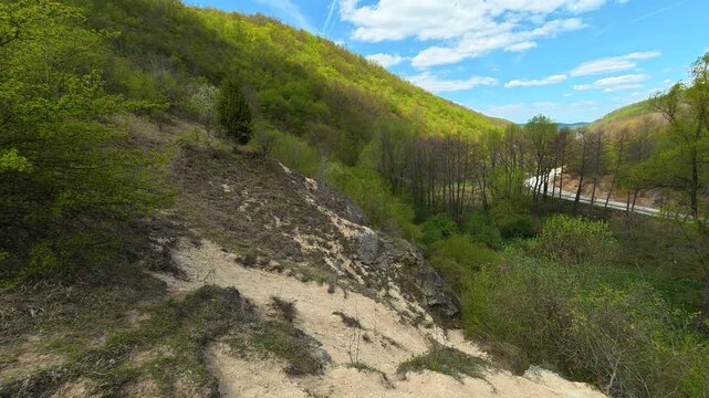 Blue clouds drift above rolling forested terrain. Bigar Waterfall, Stara Planina. (Balkan Mountains), Serbia.