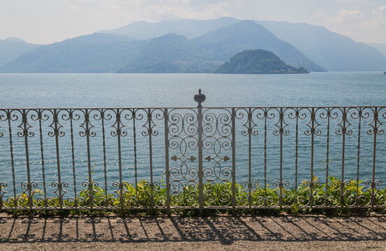 iron fence in Varenna, Italy, with view of lake Como with the Alps in the background
