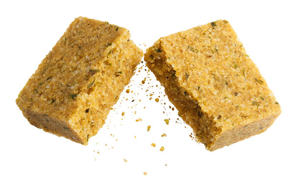 Floating halved bouillon cube with crumbs, isolated on cutout transparent background