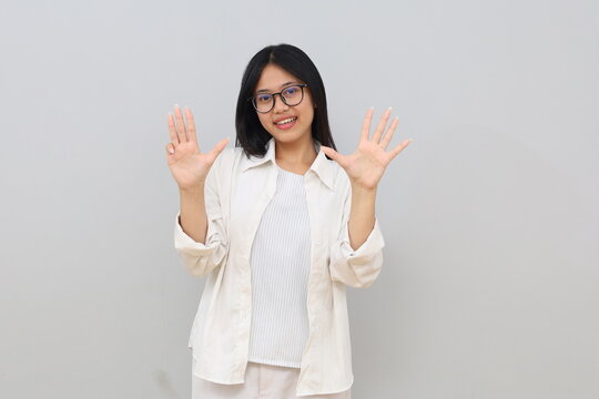 Happy and beautiful Asian girl smiling, showing nine fingers to explain the rules and steps, standing on a white background.