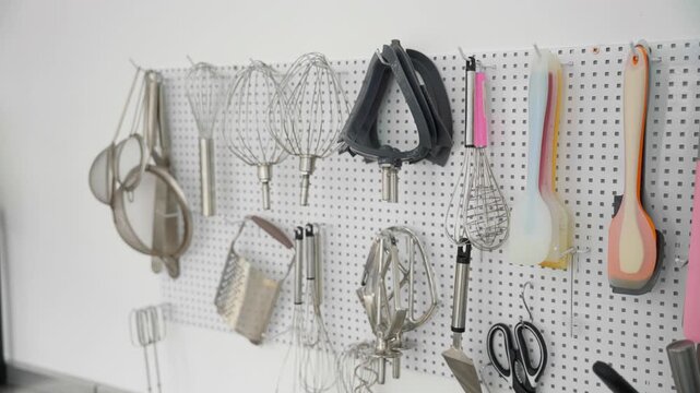 Organized baking and pastry tools hanging on a wall