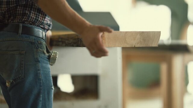Carpenter using a thickness planer on a wooden plank
