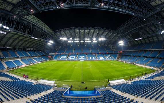 Poznan, Greater Poland, Poland - May 8, 2026: Wide panoramic interior of Lech Poznań city stadium with the full football pitch, blue seating tiers, steel roof and bright floodlights at night.