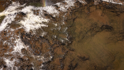 Aerial photograph of Sae Pong Lai Waterfall in Sekong Province, Laos. The powerful cascades tumble over wide rocky ledges into a churning pool, with the green tropical jungle stretching to the mountai © jr