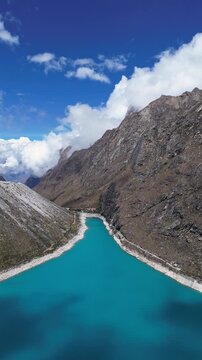 Huaraz, Peru: Footage of famous laguna paron in Caraz, Huaraz region, Peru. Surrounded by mountain range and with cloudy dramatic sky, showing cordillera blanca in the background. Taken with forward a