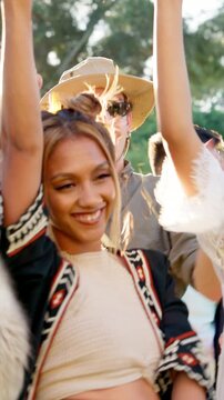 Friends, dancing and happy at festival in summer with drinks, outdoor and excited at party in nature. People, group and spring break with alcohol, concert or rhythm with celebration on getaway