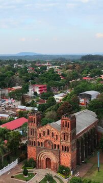 Aerial zoom in view of red brick church facade at Our Lady of Asuncion landmark in Villarrica, Paraguay