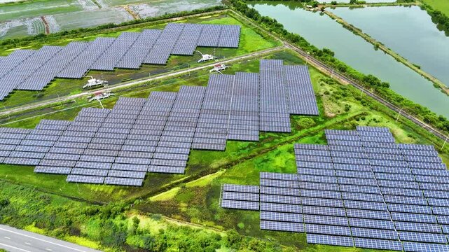 Drone footage aerial view of large solar panel arrays beside a rural road and farmland, Clean energy renewable power generation sustainable infrastructure concept