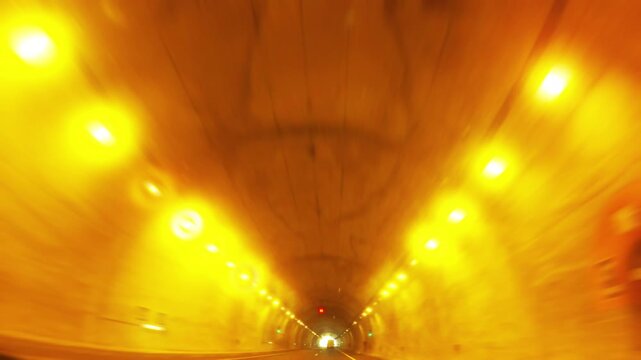 Driving through a dimly lit urban tunnel with yellow lights