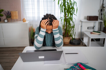 Frustrated student having headache during online studying