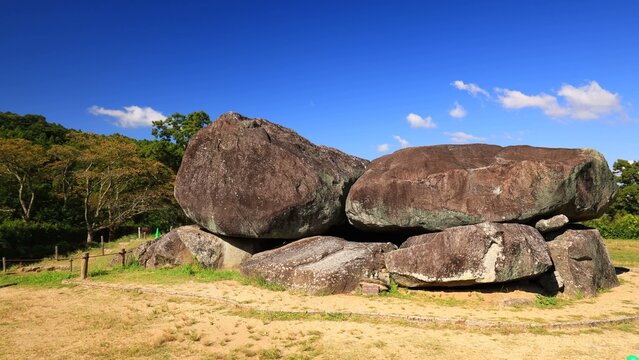 Massive megalithic tomb stones arranged in an open grassy park area