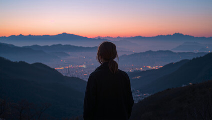 Obraz premium 夜明け前の高台で景色を眺める日本人女性の静かな写真