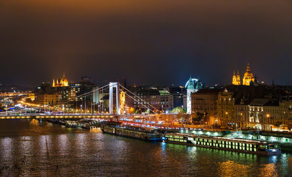 Cinematic night view of Budapest city skyline across the mighty Danube River showcasing iconic bridges and glowing Hungarian architecture during twilight hours
