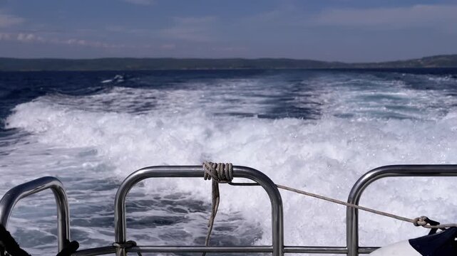 Close-up, A breathtakingly serene view from the boat, showcasing the beautiful ocean waves and intricate deck features. Texture, backgrounds. Sea voyage on a ship. Slow motion. Looped.