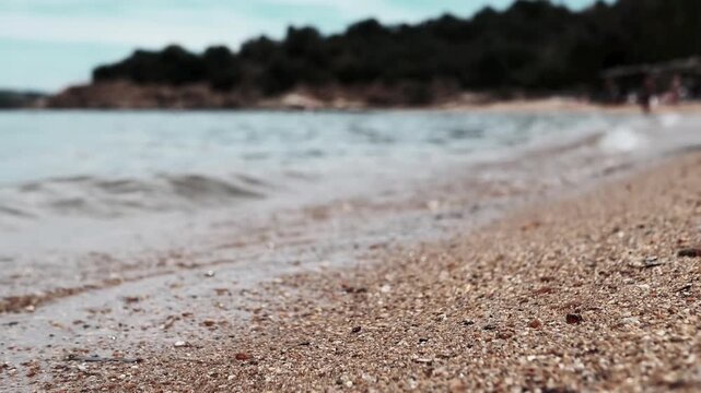 A serene beach landscape featuring soft golden sand and gently lapping waves, capturing a peaceful atmosphere. This visual evokes tranquility and relaxation, ideal for themes of vacation