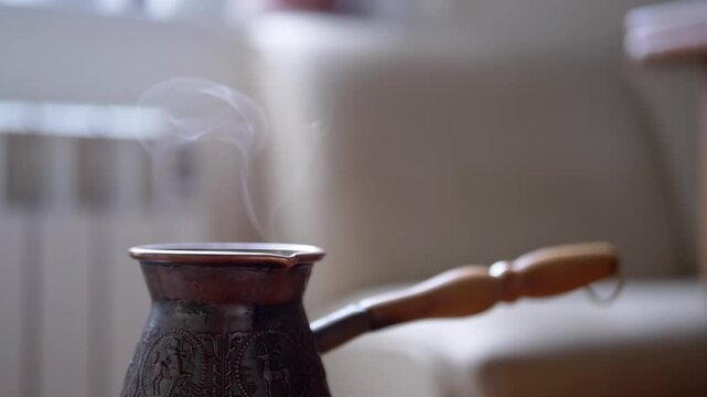 Gentle wisps of steam gracefully ascend from a classic Turkish coffee pot, suggesting a fresh and comforting brew. This scene is perfect for showcasing morning routines, relaxation, and