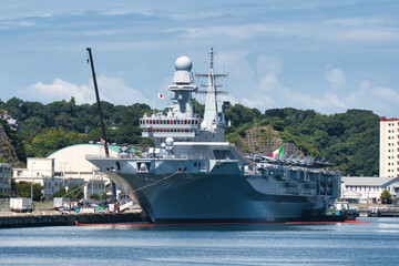 Obraz premium Large gray naval vessel moored at waterfront harbor in Japan