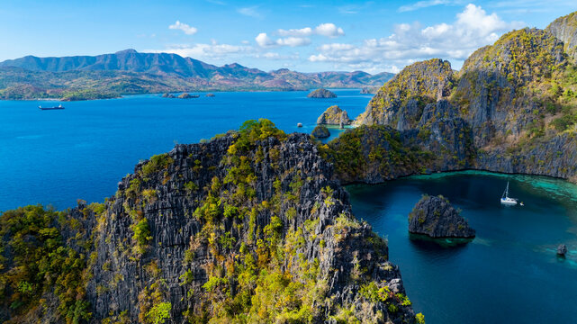 Aerial view of a beautiful tropical island with crystal clear water with limestone cliffs as the beach, Coron, Palawan, Philippines.