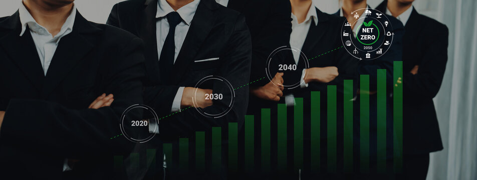 Professional business team stands confidently in suits, featuring a growth chart that tracks sustainability goals and net zero emissions achievements over time. Gantry