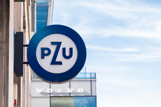 WARSAW, POLAND - 5 april 2026: Low angle view of modern glass skyscraper tower with PZU logo sign on the facade. Corporate office building architecture against a blue sky.
