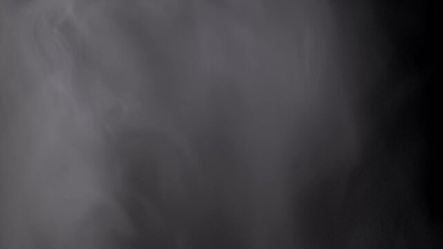 Dense white smoke billows and swirls creating an abstract, mysterious atmosphere against a solid black background. This atmospheric vapor effect is ideal for overlays and adding a dark,