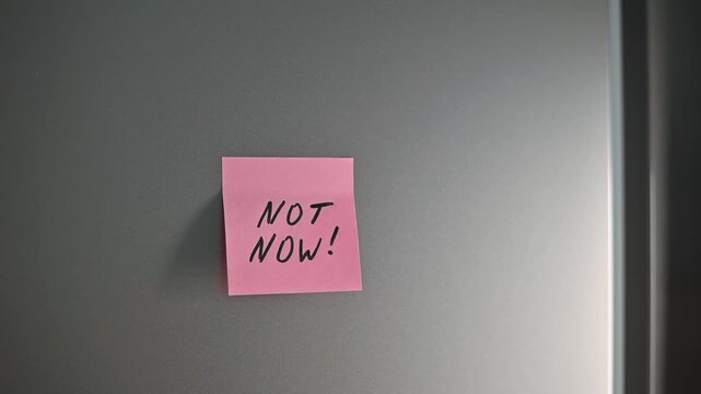 A colorful sticky note is placed on a door, repeatedly sending a message of Not now! The notes visually express the theme of communication and boundaries in a fun, light manner
