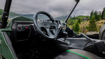 Inside view of a rugged off-road vehicle dashboard with a mountain landscape © shine.graphics