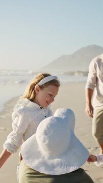 Parents, children and running on beach with hug, summer holiday and bonding together for connection. Happy people, mother and father outdoor by ocean with girl kids embrace, family vacation or travel