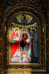 Fototapeta premium Orthodox christian icon of archangels in golden frame. Traditional religious painting of angels with a hanging oil lamp in church. Christian orthodox faith, spiritual art, cathedral interior concept