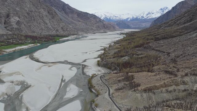 Cinematic nadir drone tracking shot of a car on the winding KKH mountain road.