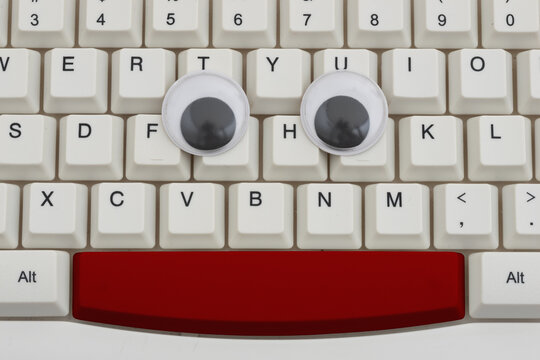Googly eyes on a white computer keyboard for tracking user activity