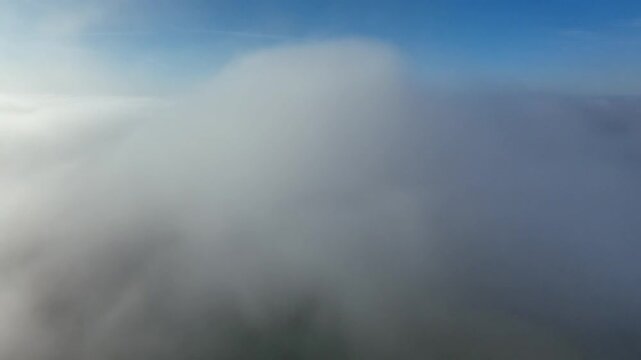 Above the clouds aerial view with sunlit sky and thick white clouds