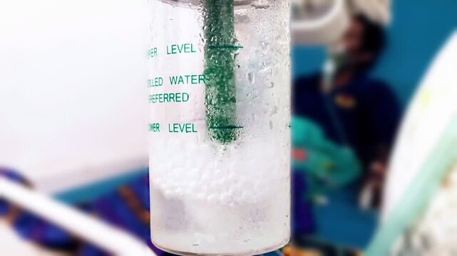 Close-up of bubbling water in an oxygen flow meter, providing vital medical support to a patient, capturing a moment of critical care delivery