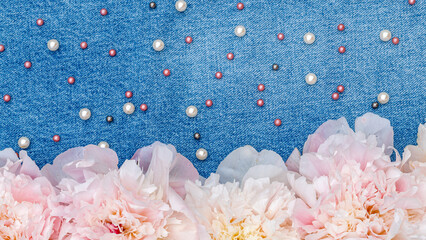 Obraz premium Flowers and beads arranged on denim fabric create a colorful display for craft projects