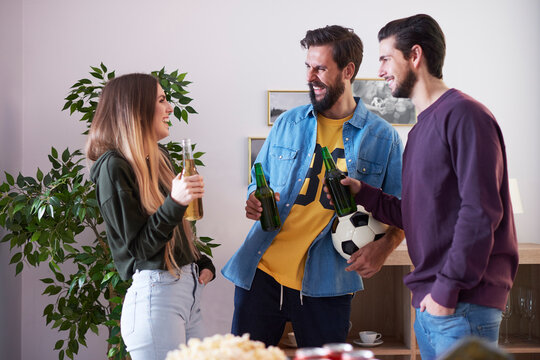 Laughing friends socializing with beer and snacks