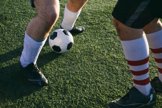 Legs of football players on football ground