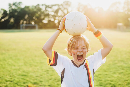 Boy wearing German soccer shirt screaming for joy
