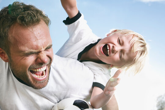 Germany, Cologne, Father and son playing soccer