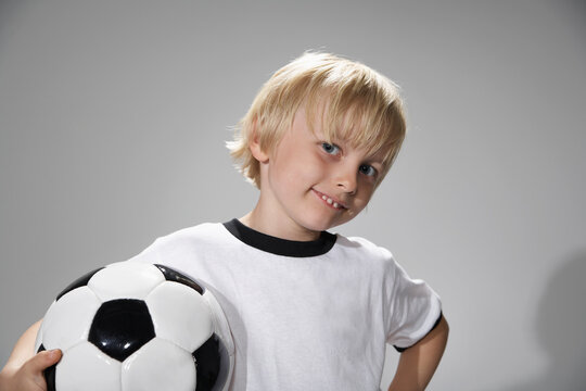 Boy in soccer jersey holding ball