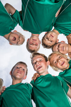 Happy young football players huddling